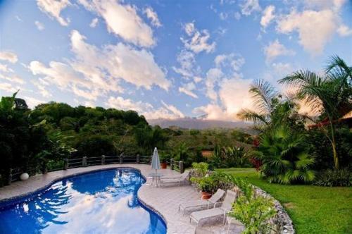 奎波斯城蓝悦榕庄酒店 的云天的院子中的游泳池