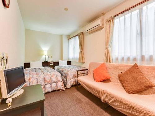宫崎鹤立花酒店的酒店客房设有两张床和一台平面电视。