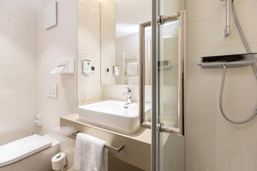 里斯河畔比伯拉赫卡普兹奈霍夫酒店的白色的浴室设有水槽和淋浴。