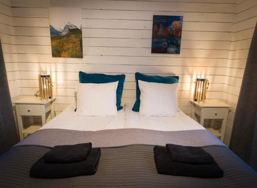 基律纳北极美食山林小屋的一间卧室配有一张带两个枕头的床