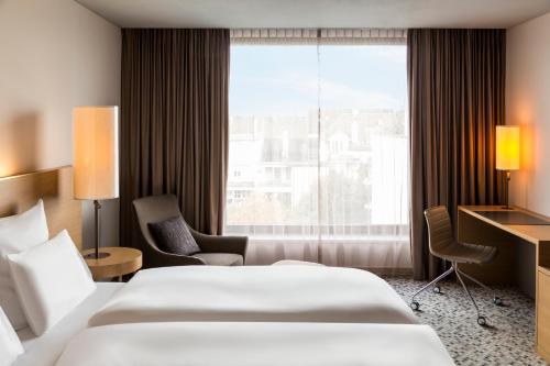巴塞尔欧洲巴塞尔铂尔曼酒店的酒店客房设有两张床和窗户。