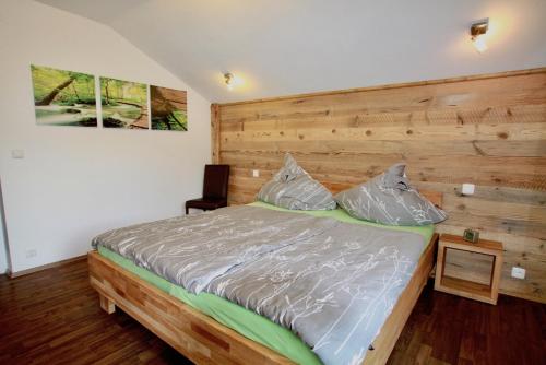菲伯布伦Basislager Fieberbrunn的一间卧室配有一张大床和木制床头板