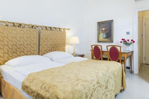 布拉格Hotel Bologna的卧室配有一张床和一张桌子及椅子