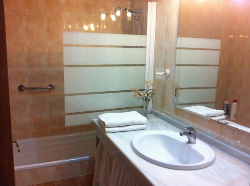 塞维利亚Milenium Palace - Garaje incluido - Piscina-FIBES的浴室配有盥洗盆、镜子和浴缸