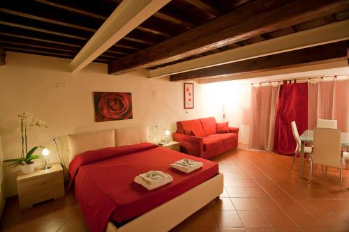 佛罗伦萨Relais Florence Duomo的一间卧室配有红色的床和椅子