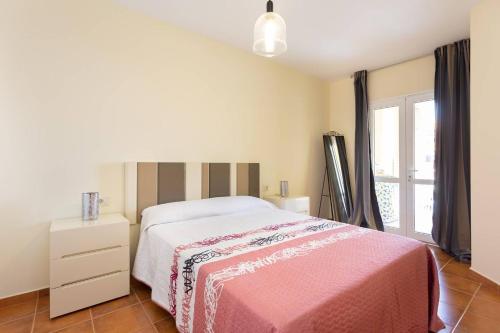 圣伊西德罗piso san isidro的一间卧室配有一张带粉色毯子的床