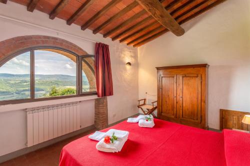 佩萨河谷塔瓦内莱奎尔切托农庄乡村民宿的一间卧室设有一张红色的床和大窗户