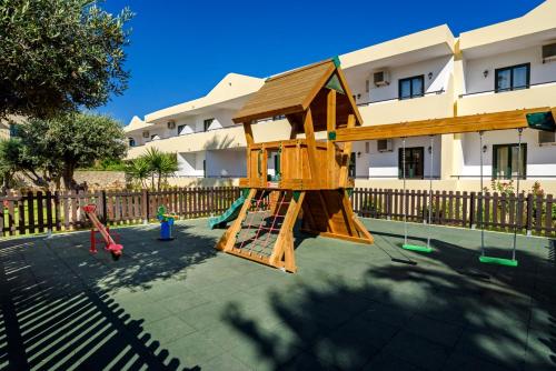 佩基罗德佩克斯度假村公寓式酒店的一座带木游戏结构的游乐场,位于一座建筑前
