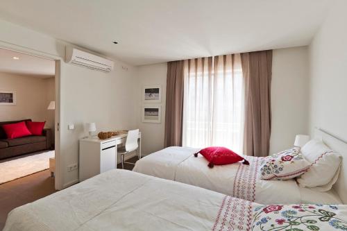 波尔图帕拉西奥波娜公寓式酒店的一间带两张床的卧室和一间客厅