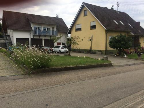 BroggingenBreig,s Ferienwohnung的街上的黄色房子和白色汽车