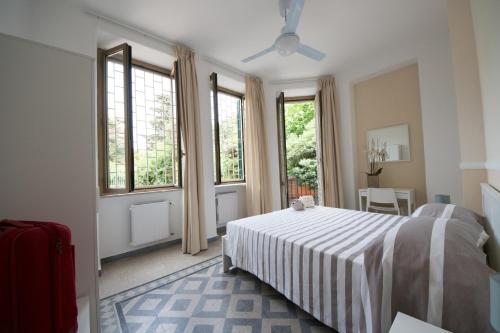 安齐奥Ostello San Luigi Orione的一间卧室配有一张带条纹毯子的床和窗户。