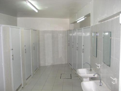 拉巴特Auberge De Jeunesse的白色浴室设有两个盥洗盆、镜子和摊位