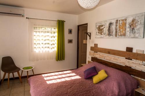 圣罗斯Fleur de canne的卧室配有床、椅子和窗户。