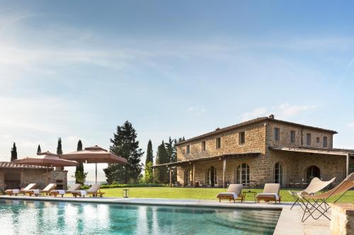 Castiglione del Bosco托斯卡尼瑰丽酒店的大楼前带游泳池的房子