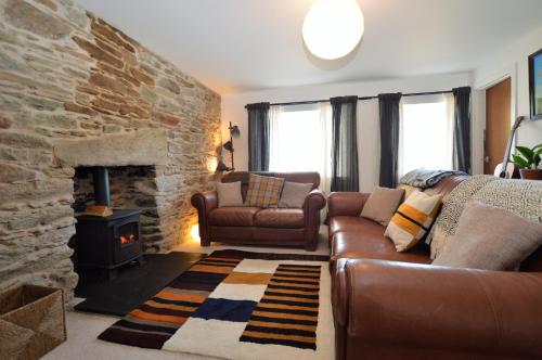 泰纳布鲁厄赫Gate Cottage的带沙发和石制壁炉的客厅
