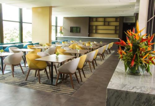 麦德林Hotel Estelar Square的用餐室配有桌子和黄色椅子