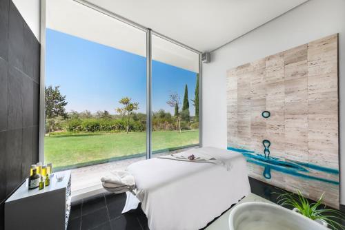 埃武拉艾斯品赫罗修道院历史Spa酒店的一间带白色浴缸和大窗户的浴室