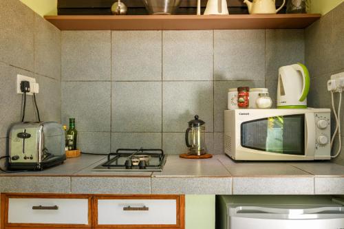 马埃岛贝拉扎尔区索雷尔庄园旅馆的厨房柜台配有微波炉和炉灶。