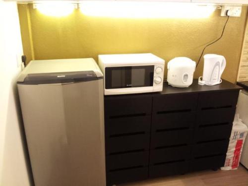 亚依淡Fastbook Bendera Home 8 & 10pax的微波炉,位于台面上,配有冰箱