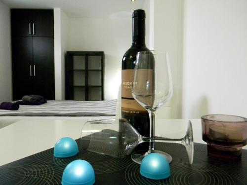 克拉古耶瓦茨Apartments Luka的一瓶葡萄酒和一张桌子上的一杯