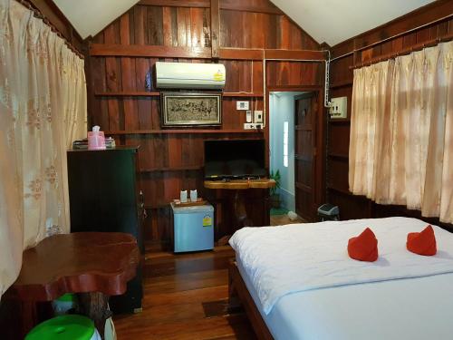 武里南Greenhouse resort的一间卧室配有一张带红色枕头的床
