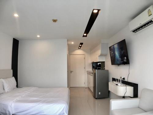 芭堤雅市中心City Center Residence By Pattaya Sunny Rentals的一间卧室配有一张床、一台电视和一张沙发