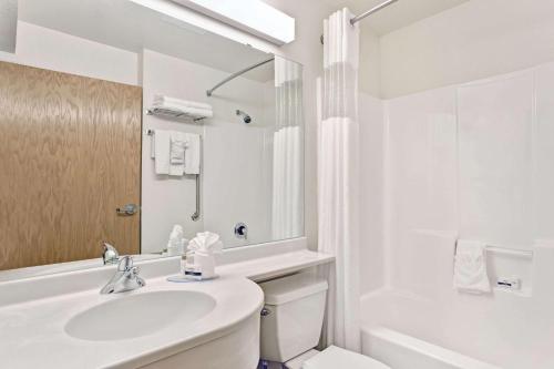 夏延夏安麦克罗特客栈&套房的白色的浴室设有水槽、浴缸和卫生间。