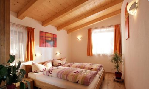 布利克森塔勒安内玛瑞公寓的一间卧室配有床和橙色窗帘的窗户