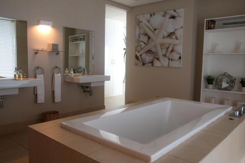 斯坦格25 Sovereign Sands的一个带两个水槽的浴室内的白色大浴缸