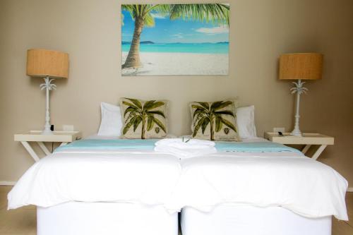 斯坦格25 Sovereign Sands的一间卧室,床上有棕榈树