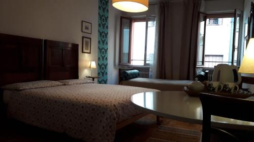 特雷维索B&B Barberia的一间卧室配有一张床、一张桌子和一张沙发