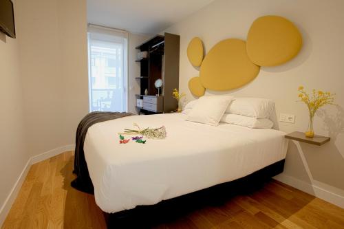 奥利奥Smart Urban Orio的一间卧室配有一张白色大床,床上有鲜花