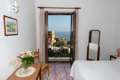 波西塔诺玛丽亚安东尼塔别墅酒店的一间卧室配有一张床、一张桌子和一个窗户。