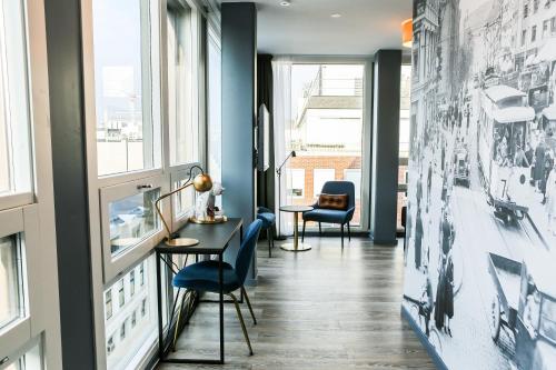 奥斯陆The Verdandi Hotel的走廊设有蓝色的墙壁、窗户和蓝色的椅子