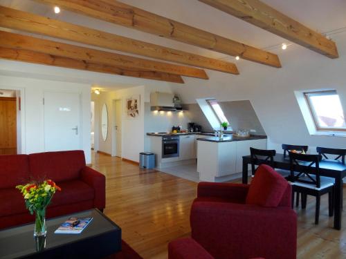 费马恩Ferienwohnungen Hass - Haus 10的一间带红色沙发的客厅和一间厨房