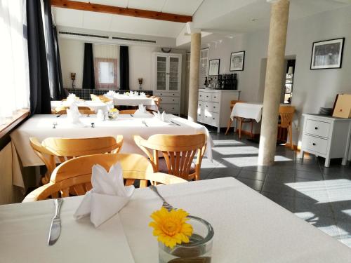 KaunsGasthof Falkeis的用餐室配有白色的桌子和木椅