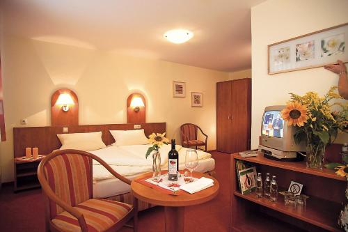 瓦尔特尔斯豪森Landgasthof Zur Tanne的酒店客房设有一张床和一张桌子及一台电视