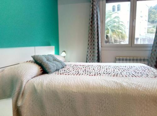 雷凯蒂奥Apartamento centrico en Lekeitio, playa y puerto的一间卧室设有一张带绿色墙壁和窗户的床。