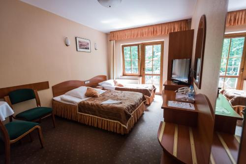 格武霍瓦济Gościniec pod Bukiem的酒店客房设有两张床和电视。