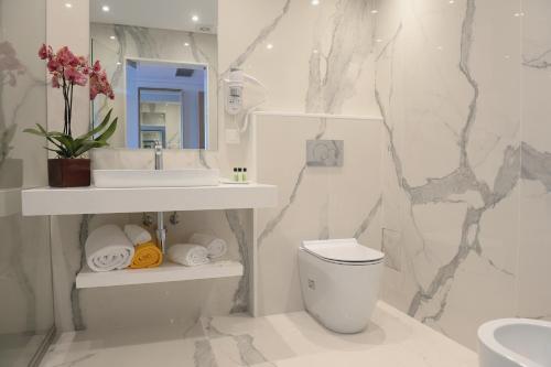 丰沙尔海洋花园酒店的一间带卫生间、水槽和镜子的浴室