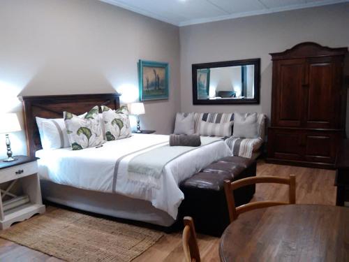 彼得马里茨堡Welcome Home Cottages的卧室配有一张白色的大床和一张桌子