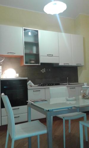 特尔尼Belvedere Valenza的厨房配有白色橱柜和桌椅