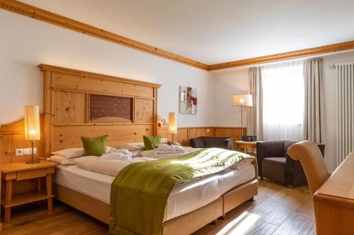 圣克里斯蒂娜多斯维塔尔品纳酒店的一间卧室配有一张大床和木制床头板