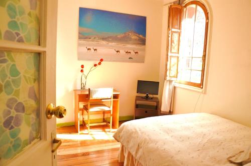 圣地亚哥特拉尔肯住宿加早餐酒店的一间卧室配有一张床、一张书桌和一个窗户。