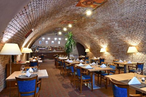 塔博尔德沃夏克塔博尔LH会议及康体酒店的餐厅设有木桌和椅子,拥有砖墙