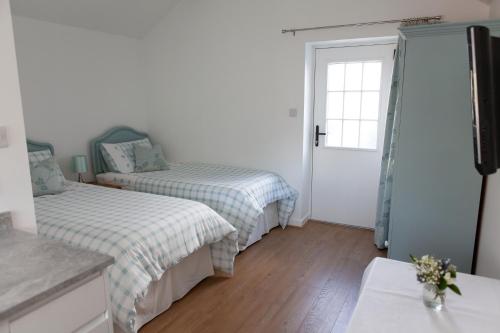 WhitegateElm Cottage Touring Park的一间卧室设有两张床和窗户。