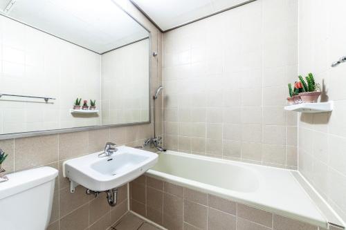 束草市HK Resort的一间带水槽、浴缸和镜子的浴室