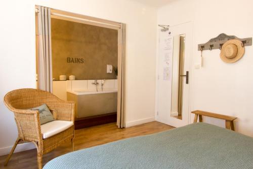 勒宝利古恩Casa Cosy Le Pouliguen的一间卧室配有一张床,浴室设有浴缸