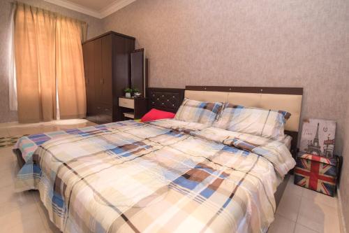 甘邦康卡普拉Skudai Homestay Pulai Perdana near UTM JPO and Taman Universiti的一间卧室配有一张大床和一张铺着条纹毯子