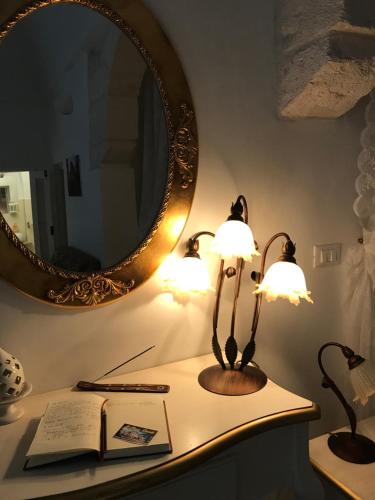 奥斯图尼Il Pumo Dorato的一张桌子,上面有两盏灯和一面镜子